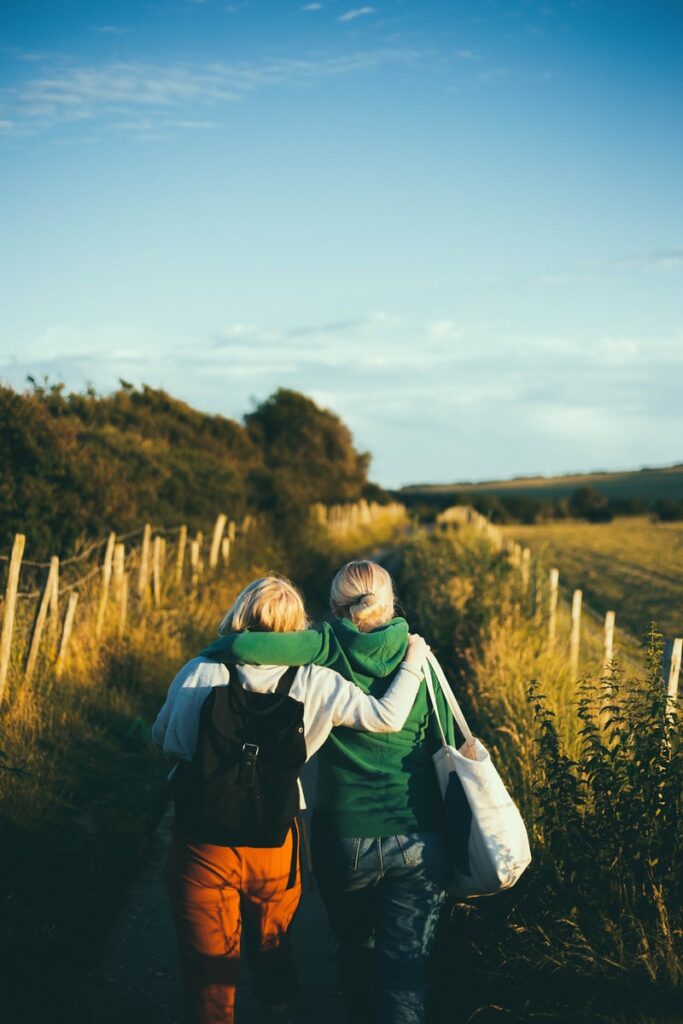 two women walking together outdoor during daytime