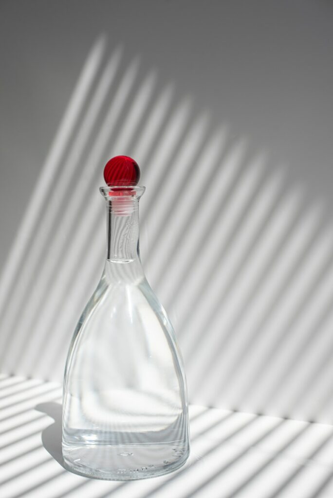 clear glass bottle with red lid