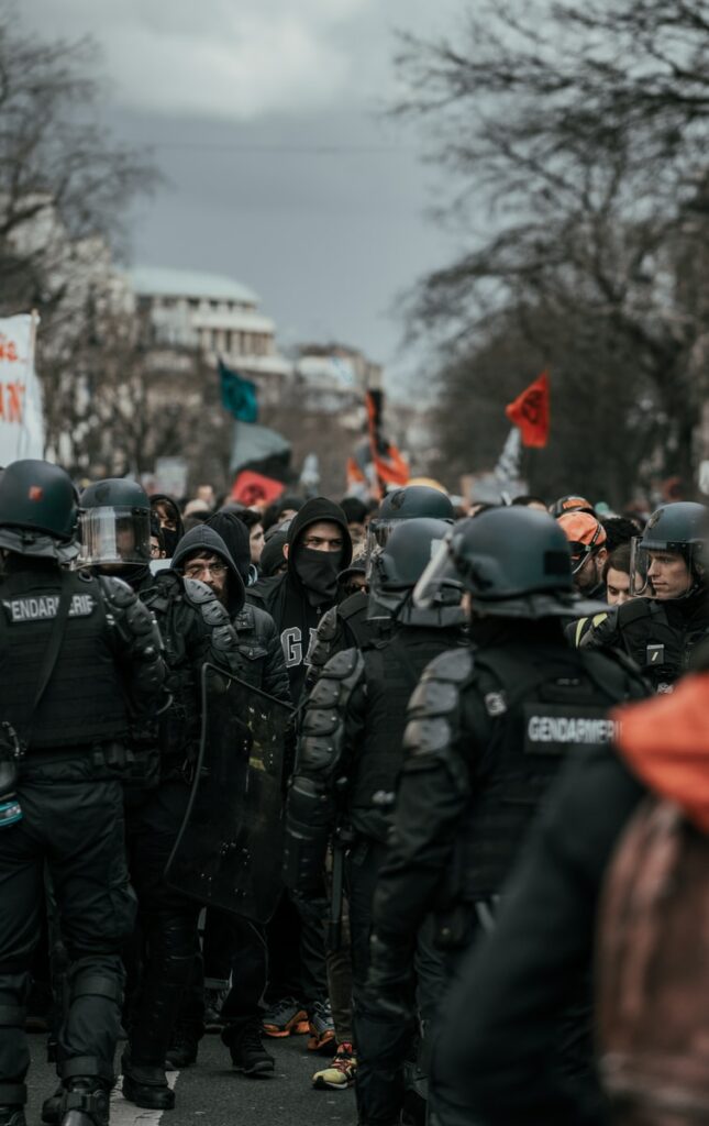 group of men in black and gray helmet standing on road during daytime