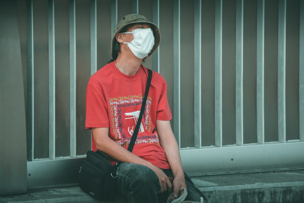 man in red crew neck t-shirt wearing white sunglasses sitting on black chair