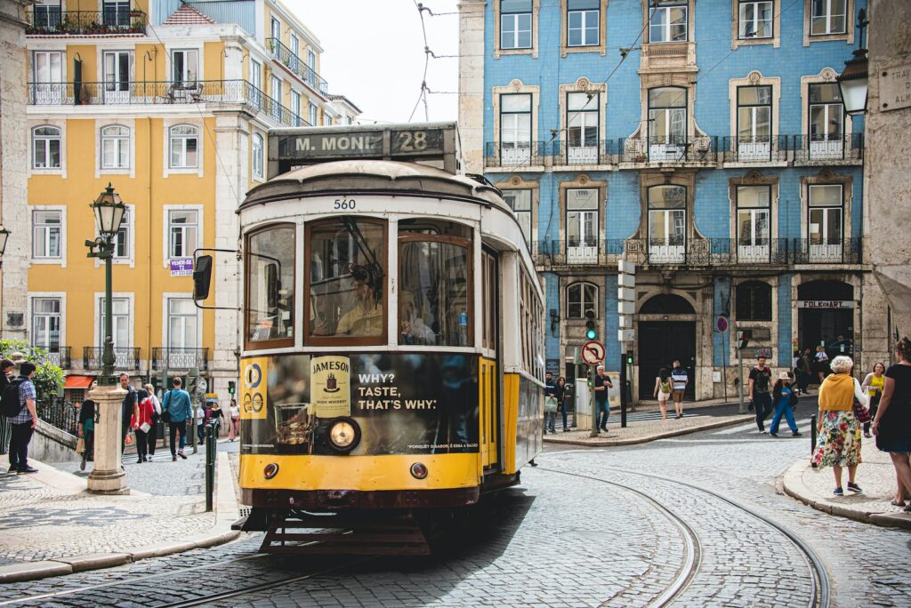 yellow and white tram on road near white concrete building during daytime