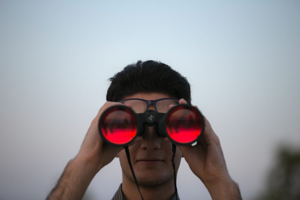 person holding black binoculars