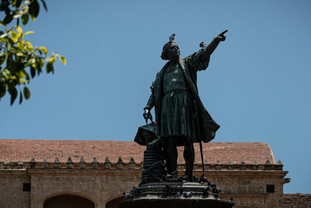 black statue of man holding yellow umbrella