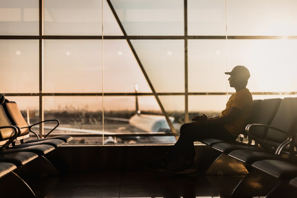 man sitting on gang chair near window