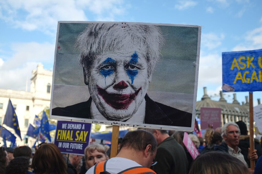 person holding man wearing clown face art