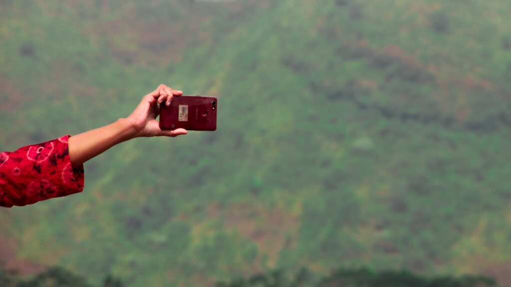 person holding maroon smartphone