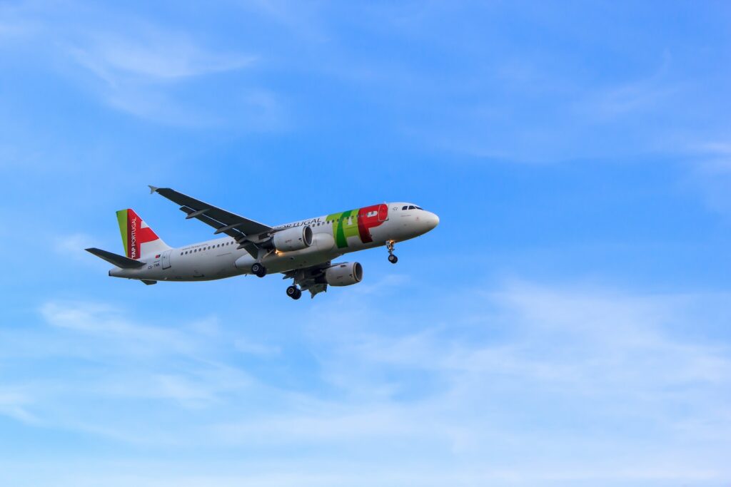 flying white and red airliner plane