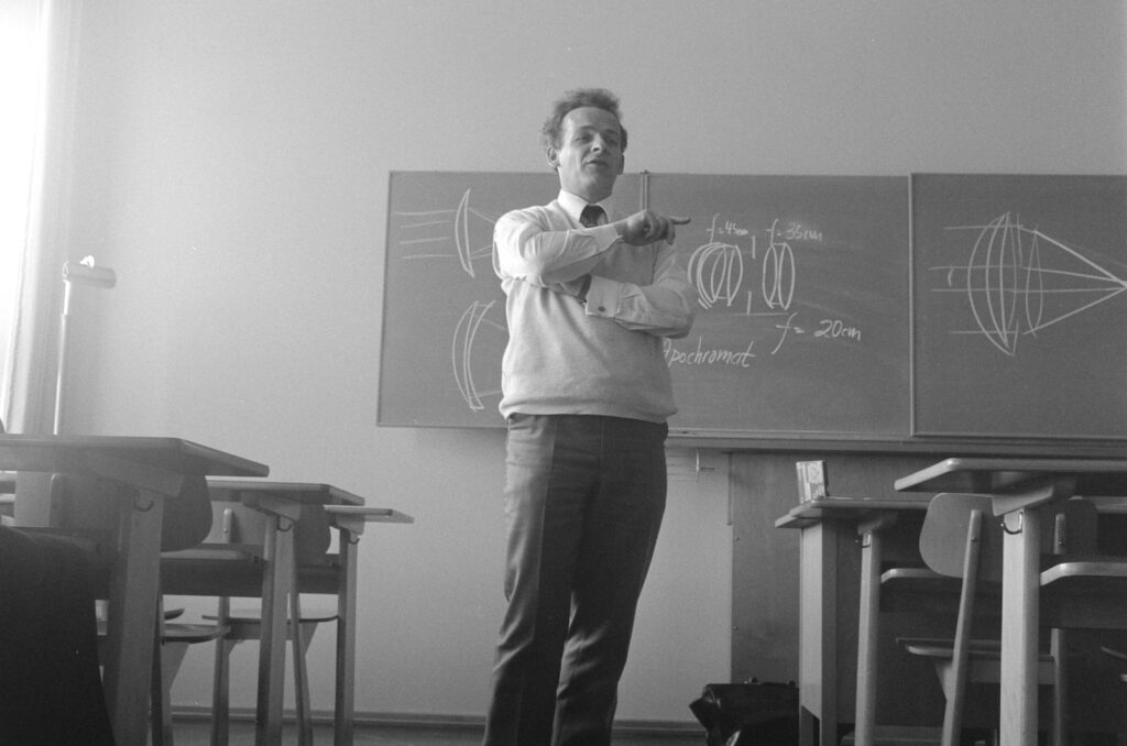 man in gray crew neck t-shirt and black pants standing near black wooden table