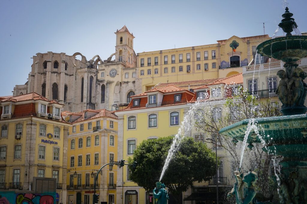 a fountain in front of a row of buildings