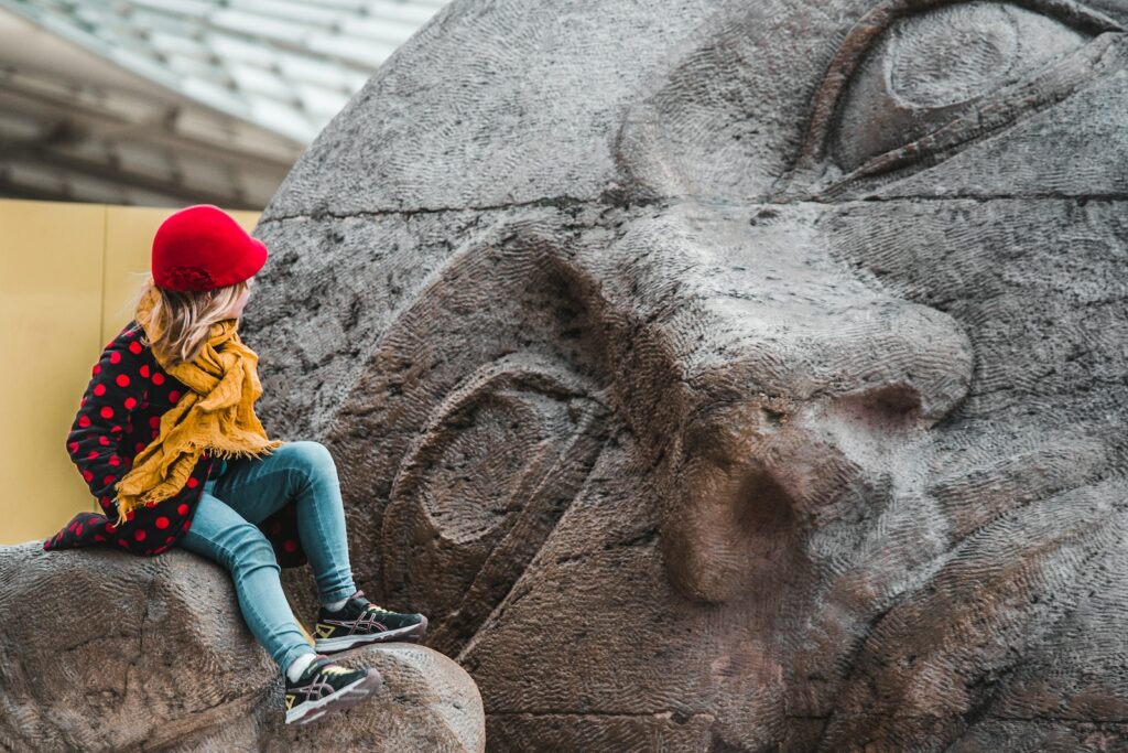 a woman sitting on top of a stone statue