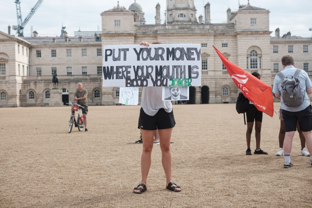 woman in black mini skirt holding white and blue banner