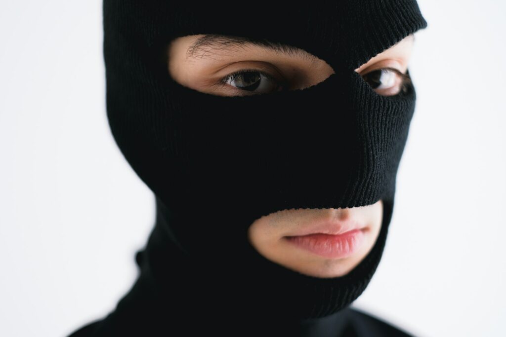 Close-Up Shot of a Person Wearing a Robber Mask