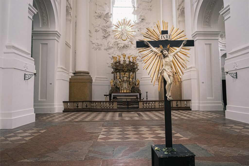 gold and black cross on white concrete building