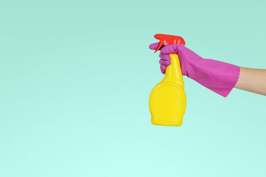 person holding yellow plastic spray bottle