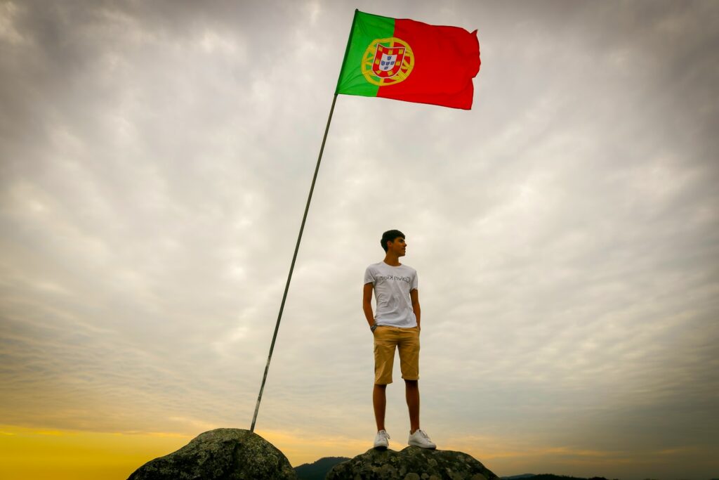 man in white t-shirt and brown shorts standing on rock