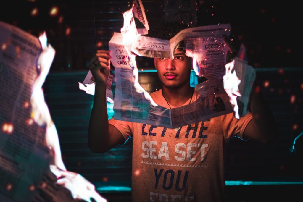 Man Holding Burning Newspaper