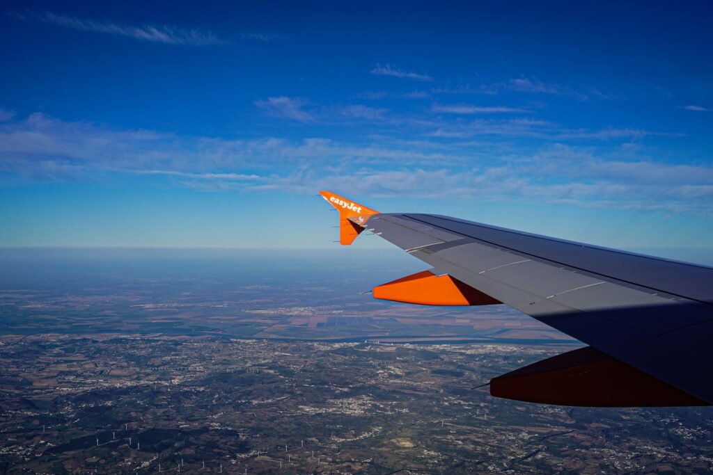 the wing of an airplane flying over a city