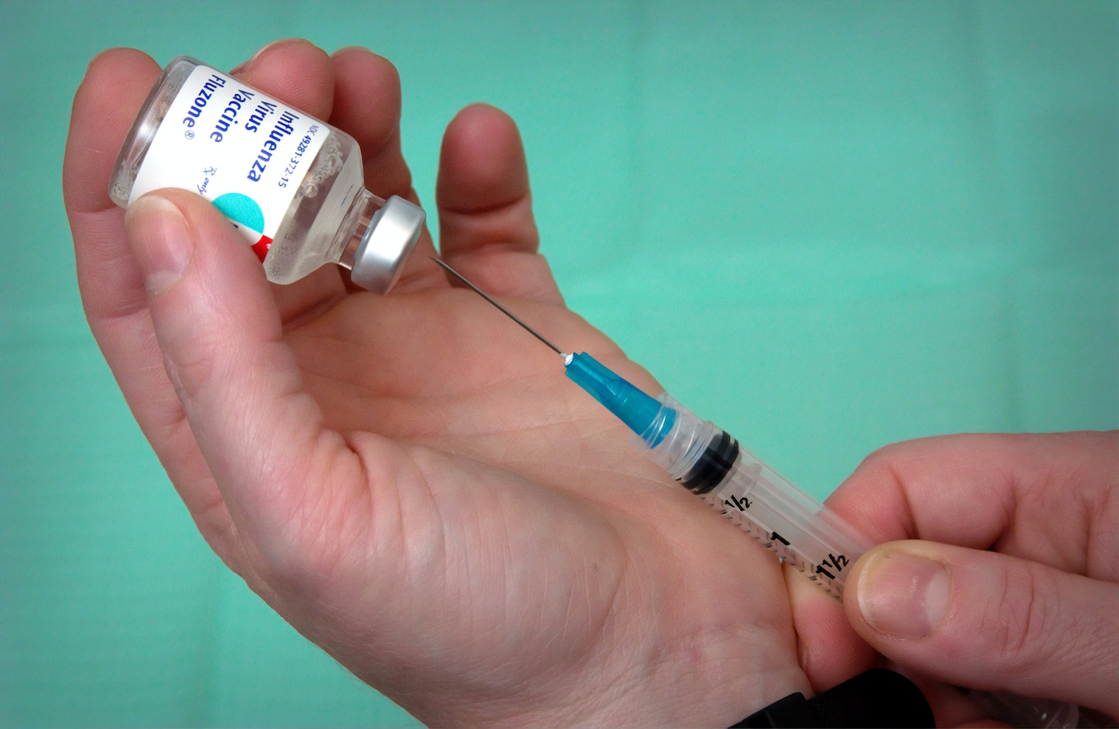 person holding syringe and vial