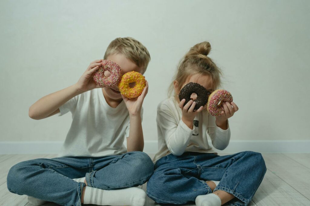 Girl and Boy Fooling Around with Doughnuts