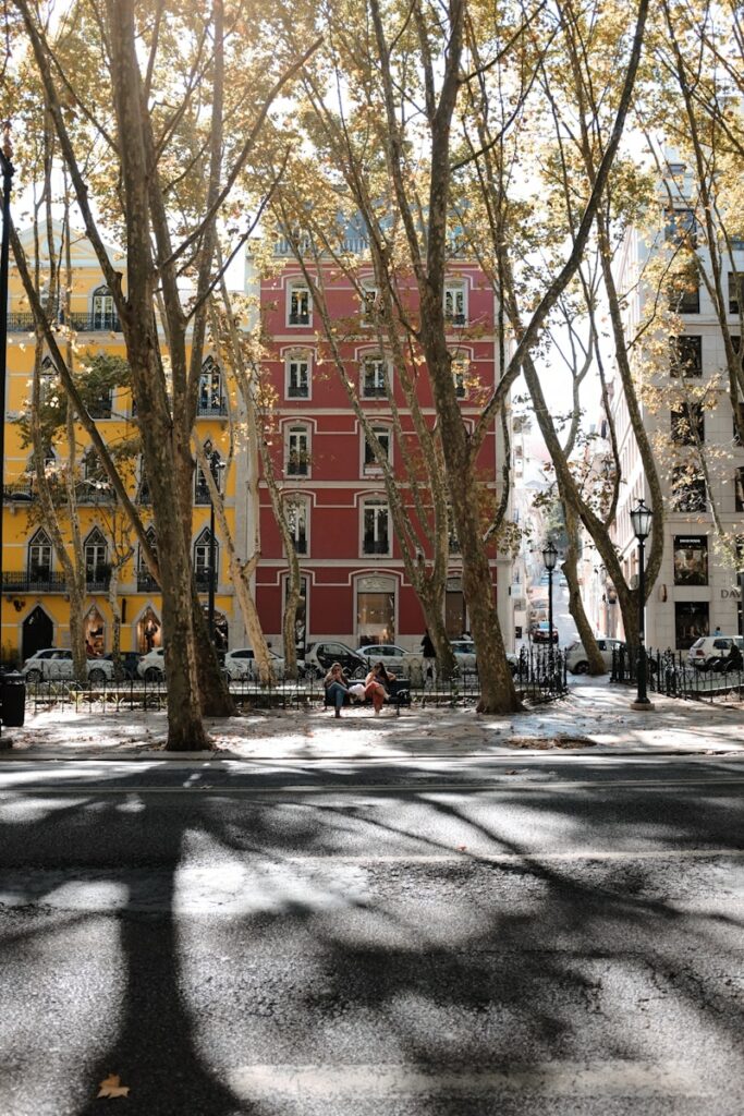 a city street with a red building in the background