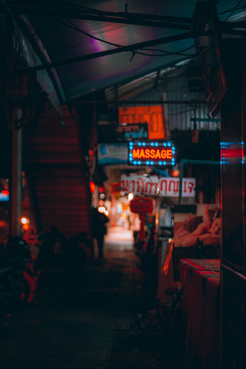 people sitting on chair near store during night time