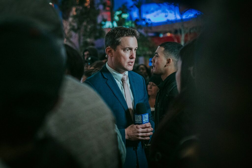 man in black suit standing in front of man in black suit