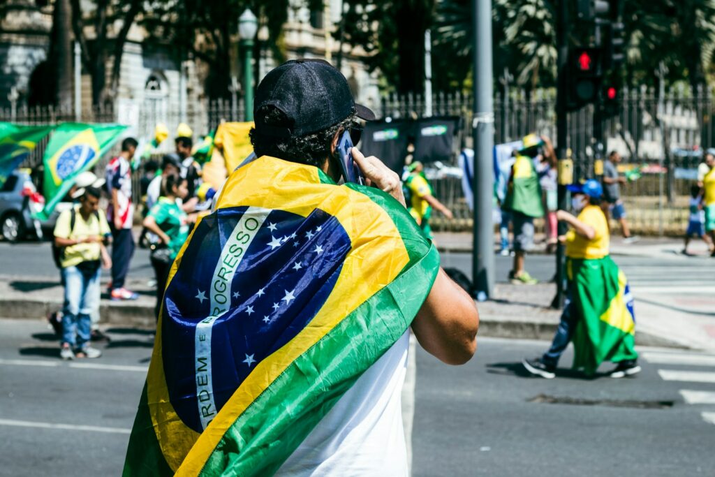 a man with a flag on his back walking down the street