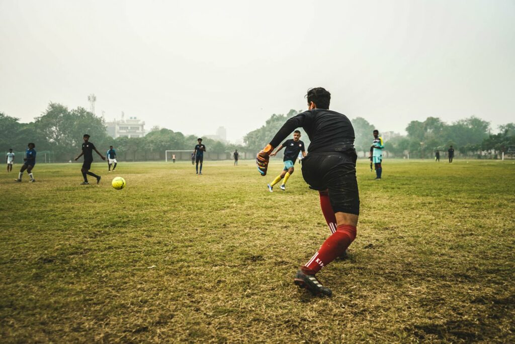 People Playing Soccer on Grass Field during Day