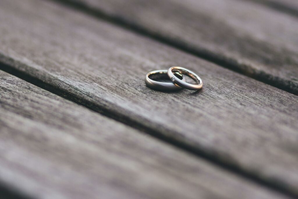 Elegant two-tone wedding rings on rustic wooden surface, symbolizing love and unity.