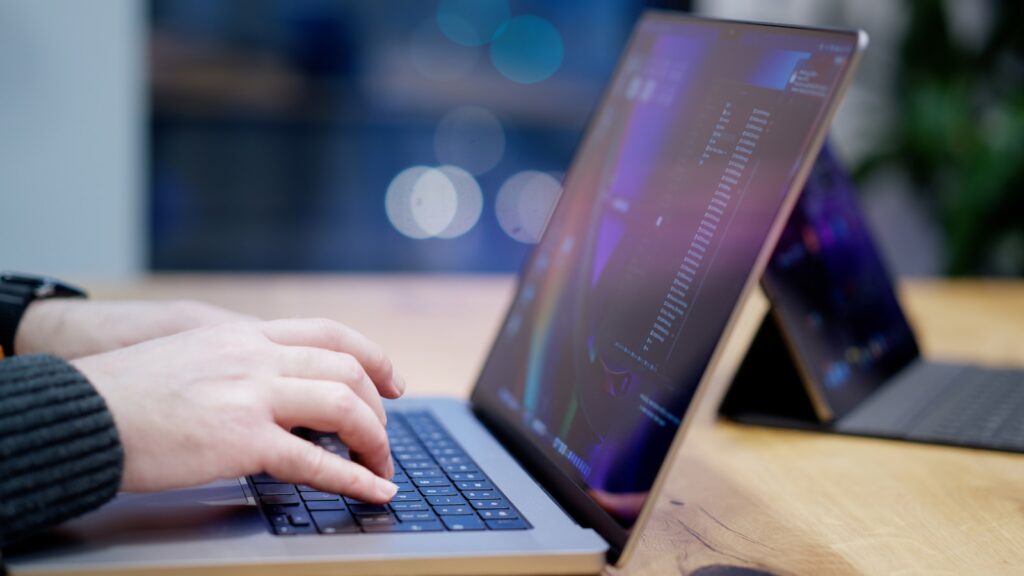 A person typing on a laptop on a desk