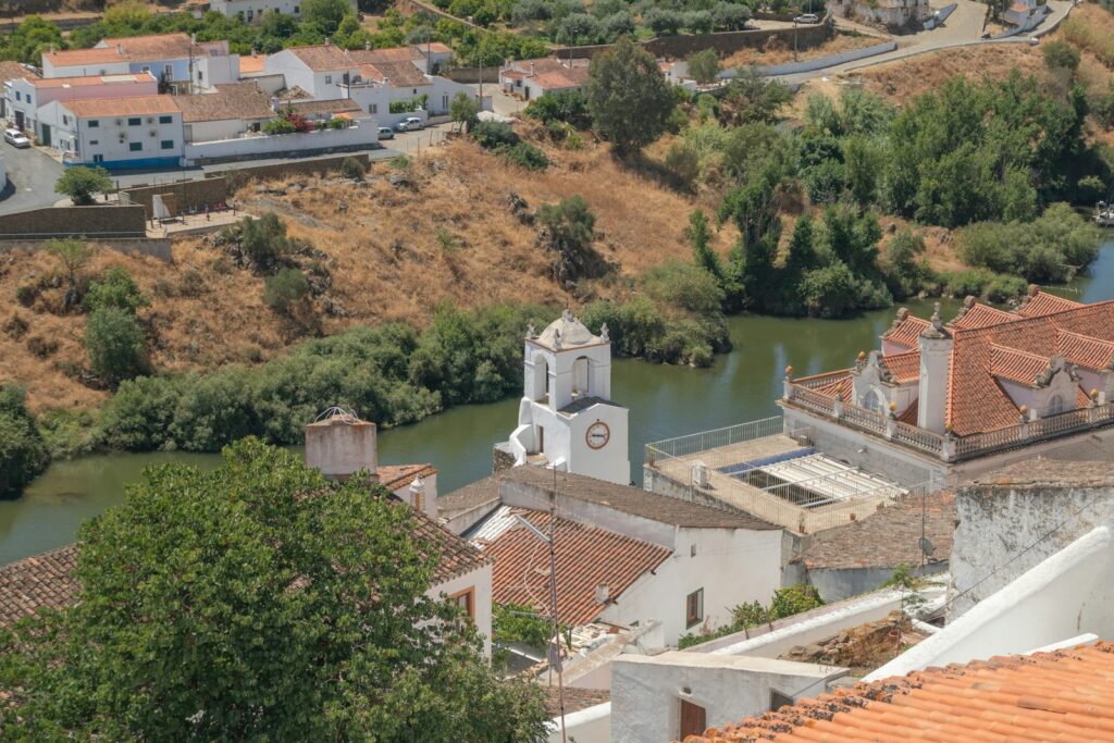 A river running through a small town next to a hillside